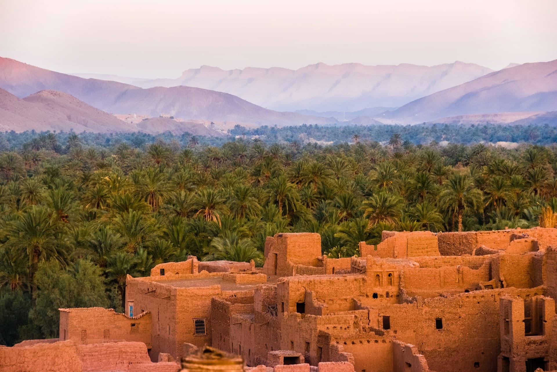 Scenic view of a Moroccan city with traditional architecture, minarets, and the distinctive terracotta-colored buildings characteristic of the region.